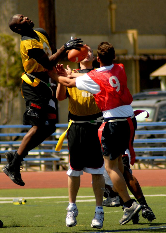 US Navy 100818-N-8283S-399 Seaman Semanya Lowe, assigned to the amphibious assault ship USS Boxer (LHD 4) tries to intercept a pass during a flag football game versus the amphibious assault ship USS Bonhomme Richard (LHD 6) as
