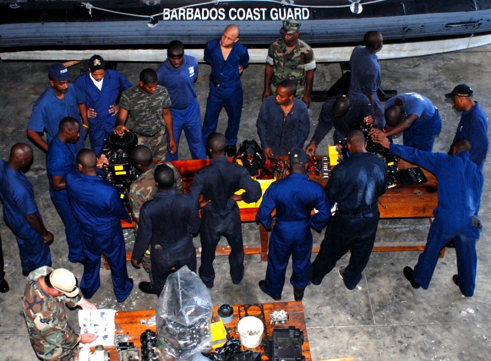 US Navy 100817-N-4971L-021 Members of the Royal Barbados Defense Force disassemble a small boat engine during a maintenance management subject matter expert exchange
