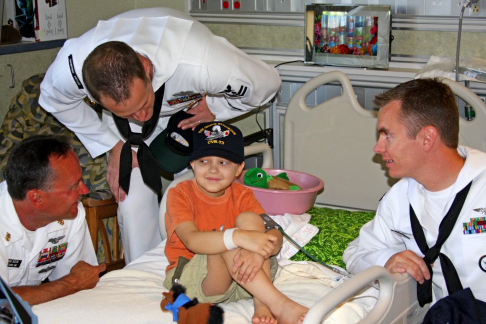 US Navy 100820-N-3038C-109 Command Master Chief Dave Bisson and area Sailors present a Navy ball cap to a patient at St. Luke's Children's Hospital during Boise Navy Week