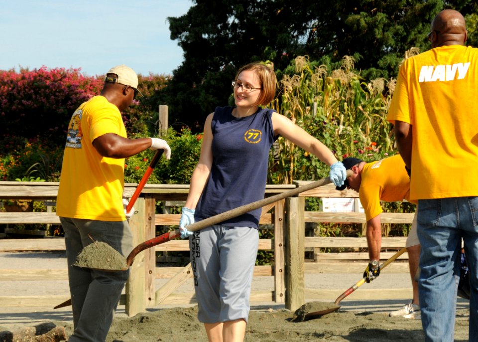US Navy 100817-N-8560K-100 Yeoman 1st Class Jessica L. Conklin helps distribute gravel around the goat pen at Norfolk Zoo during the