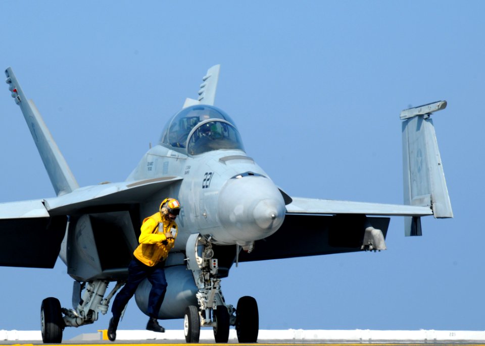 US Navy 100820-N-7908T-398 A Sailor runs with an F-A 18F Super Hornet assigned to Strike Fighter Squadron (VFA) 106 as it taxies aboard the aircraft carrier USS George H.W. Bush (CVN 77)
