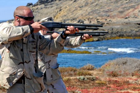 US Navy 100820-N-9123L-162 Navy Reserve Information Systems Technician 2nd Class Michael Sprinkle and Electrician's Mate 2nd Class Derek Smith fire the M500 shotgun during a live-fire exercise