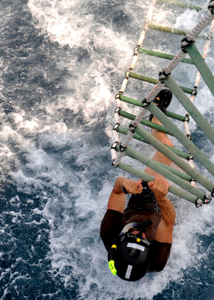 US Navy 100820-N-8959T-207 Explosive Ordnance Disposal Technician 1st Class Gregory Pruett climbs a ladder to an SH-60F Sea Hawk helicopter during a mine countermeasures training evolution