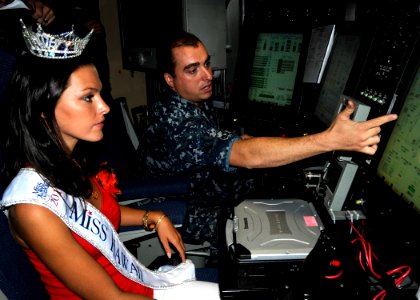 US Navy 100819-N-3560G-002 Electricians Mate 1st Class Allan Kleaving, assigned to the Virginia-class attack submarine USS Hawaii (SSN 776), explains basic submarine operations to Jalee Kate Fuselier, Miss Hawaii 2010
