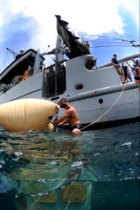 US Navy 100820-N-9769P-014 Navy Diver 2nd Class Mario Nicoletti, assigned to Company 2-6 of Mobile Diving and Salvage Unit (MDSU) 2, attaches a safety line to a salvage project that was brought to the surface using lift bags