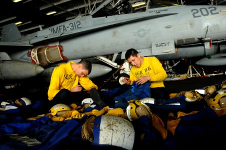 US Navy 100821-N-1092P-333 Aviation Boatswain's Mate Airman Shane Freeman, left, and Aviation Boatswain's Mate 3rd Class Ray Amaya perform routine maintenance on cranials and float-coats aboard USS Harry S. Truman (CVN 75)