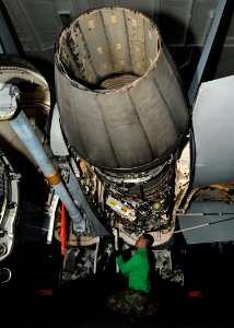 US Navy 100821-N-2686K-007 Aviation Machinist's Mate 2nd Class Vinai Keomongkhon performs maintenance on an F-A-18F Super Hornet in the hangar bay aboard USS George H.W. Bush (CVN 77)