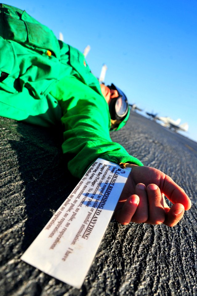 US Navy 100823-N-2953W-183 A Sailor simulates a fatal injury during a mass casualty drill on the flight deck of the Nimitz-class aircraft carrier USS Carl Vinson (CVN 70)