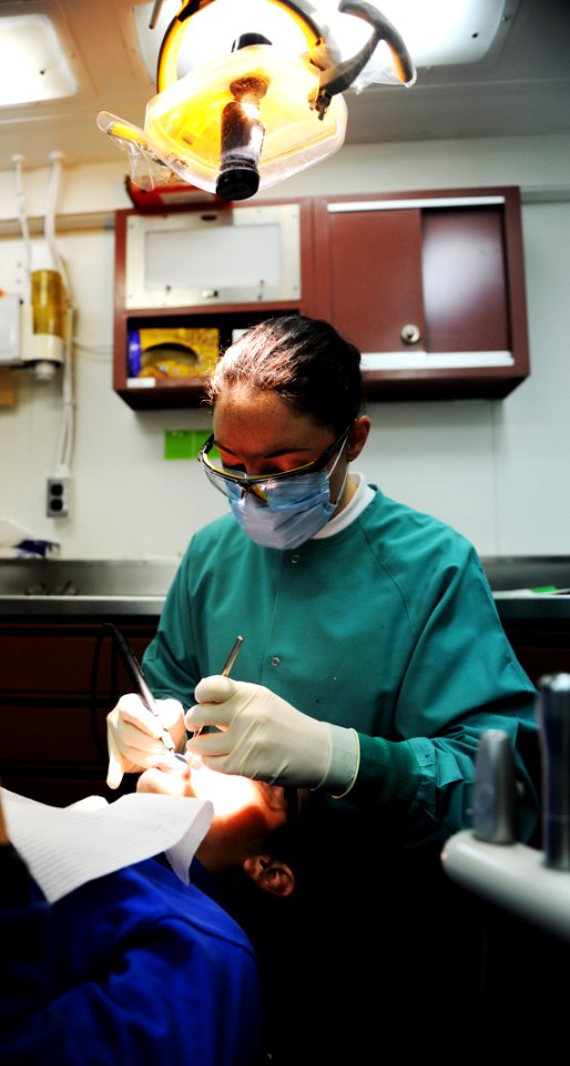 US Navy 100823-N-6362C-015 Hospital Corpsman 3rd Class Jodie Stump performs a routine dental cleaning and check-up aboard the aircraft USS Harry S. Truman (CVN 75)