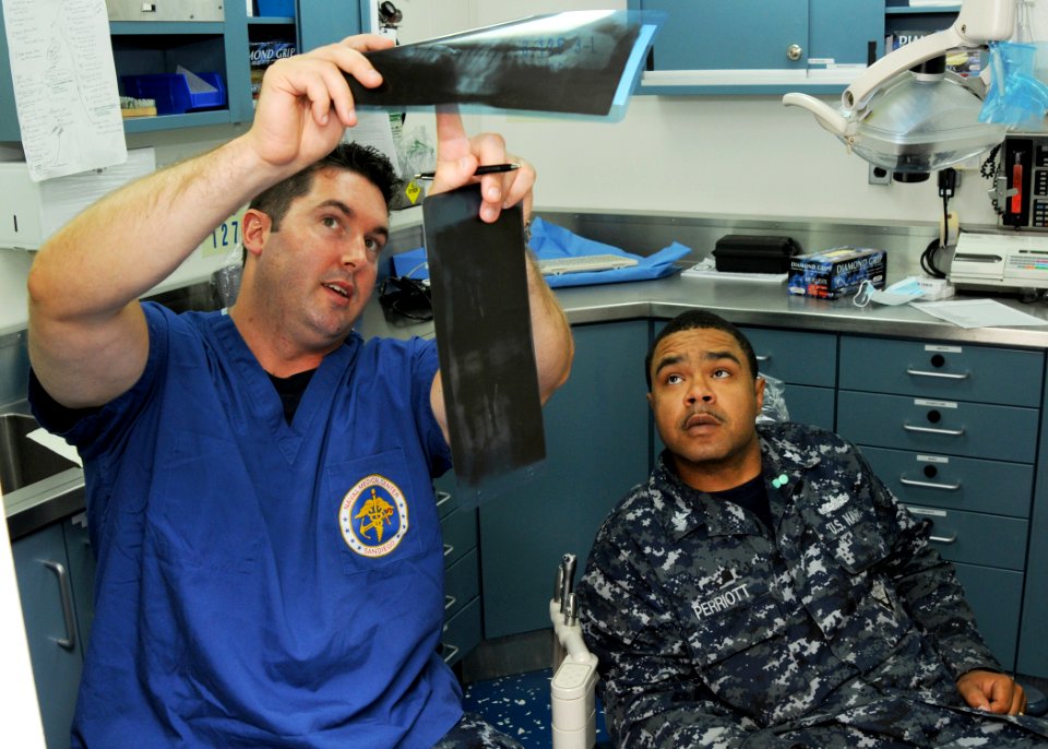 US Navy 100824-N-1004S-149 t. Frederick Rumford explains x-ray results to Machinist Mate 1st Class Tyrone Perriott during a dental examination