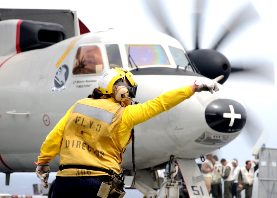 US Navy 100822-N-6632S-007 A Sailor assigned to the air department of the aircraft carrier USS George H.W. Bush (CVN 77) directs an E-2C Hawkeye