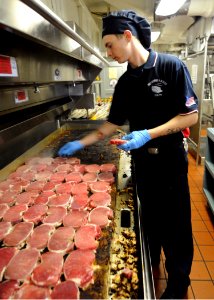 US Navy 100821-N-2686K-030 Culinary Specialist Seaman Cody D. Cunningham prepares pork chops for lunch in the galley aboard USS George H.W. Bush (CVN 77) photo