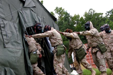 US Navy 100825-N-2888Q-001 Builder 1st Class Damian Warner holds the tent flap open as Sailors from NAVELSG Lima Rotation enter the confidence chamber