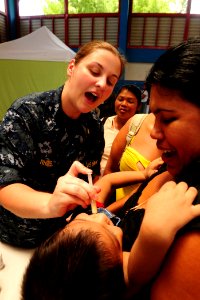 US Navy 100825-N-1531D-248 Lt. j.g. Katt Rhine, from Fort Worth, Texas, gives deworming medication to an infant during a Continuing Promise 2010 medical civic action event photo