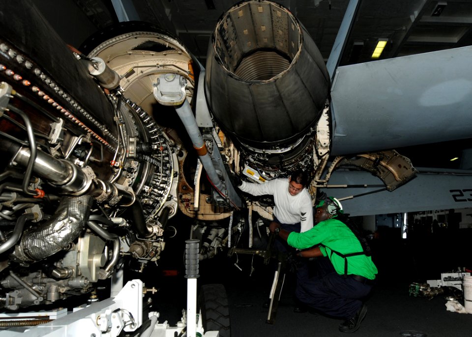 US Navy 100821-N-2686K-011 Aviation Machinist's Mate 2nd Class Kevin M. Kaleda perform maintenance on an F-A-18F Super Hornet in the hangar bay aboard USS George H.W. Bush (CVN 77)
