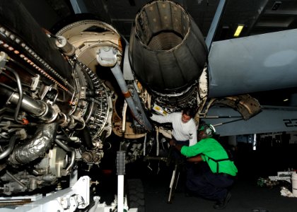 US Navy 100821-N-2686K-011 Aviation Machinist's Mate 2nd Class Kevin M. Kaleda perform maintenance on an F-A-18F Super Hornet in the hangar bay aboard USS George H.W. Bush (CVN 77)