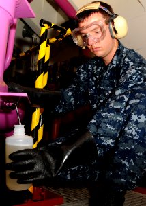 US Navy 100825-N-7908T-016 Aviation Boatswain's Mate (Fuel) Airman Matthew G. Mills akes a JP-5 fuel sample to ensure it is free from impurities