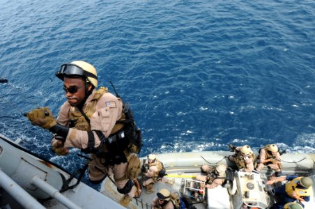 US Navy 100821-N-6463B-299 U.S. Coast Guard Maritime Enforcement Specialist 3rd Class Cleven Brown climbs a caving ladder during a mock boarding operation in the Red Sea