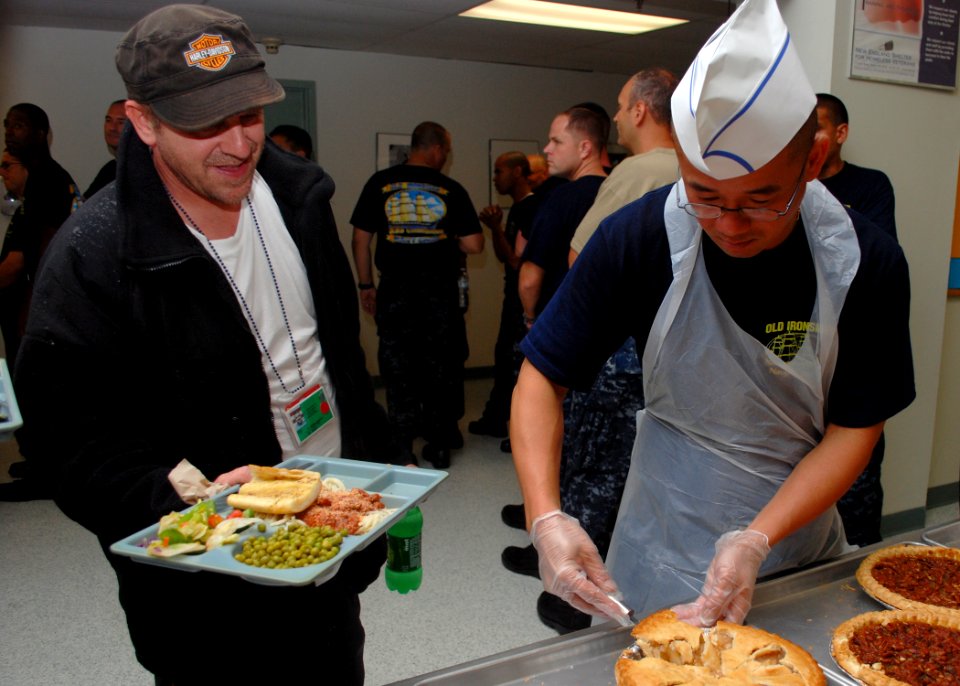 US Navy 100825-N-7642M-237 Chief Logistics Specialist (Sel.) Phillips Nguyen serves lunch to a veteran at the New England Homeless Veterans Center during chief petty officer Heritage Week, Aug. 23-Sept. 3