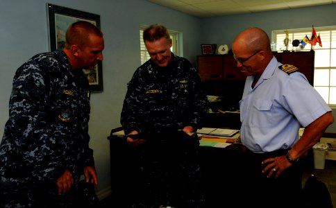 US Navy 100824-N-9643W-390 Capt. Michael Jacobsen, center, Capt. Kurt Hedberg, left, and the commanding officer of the Barbados Defense Force look at old photos photo