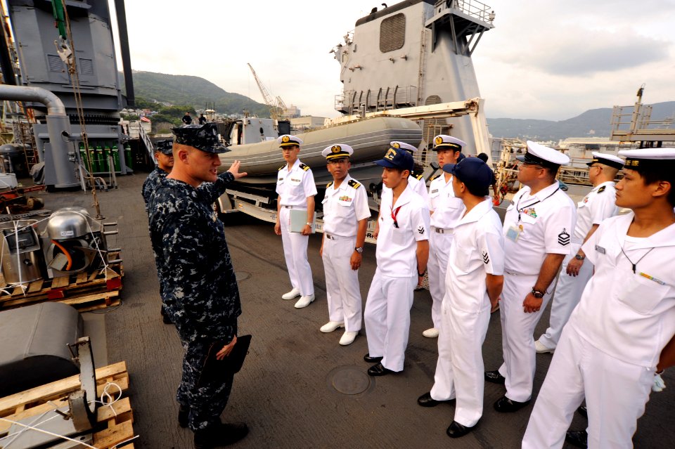 US Navy 100825-N-8335D-227 Lt. j.g. Josh Priebe shows a rigid-hull inflatable boat to a group of Japan Maritime Self-Defense Force (JMSDF) sailors as they tour USS Harpers Ferry (LSD 49)