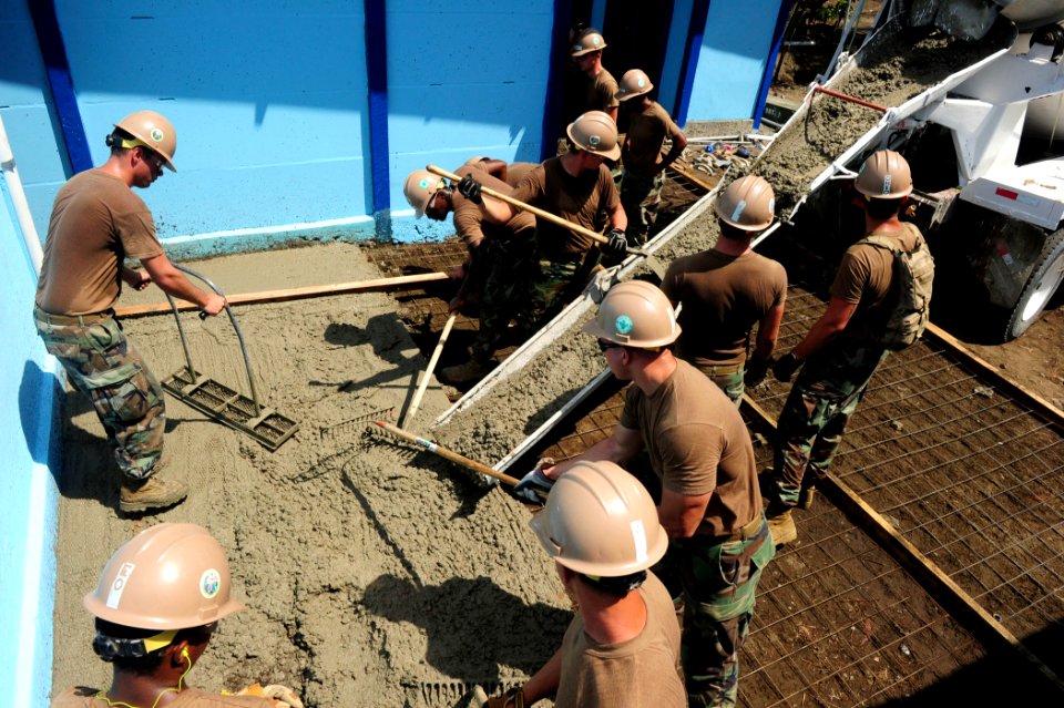 US Navy 100827-N-1531D-265 Seabees embarked aboard USS Iwo Jima (LHD 7) work together to spread cement to make a new floor at a local school during a community relations project in Limon, Costa Rica