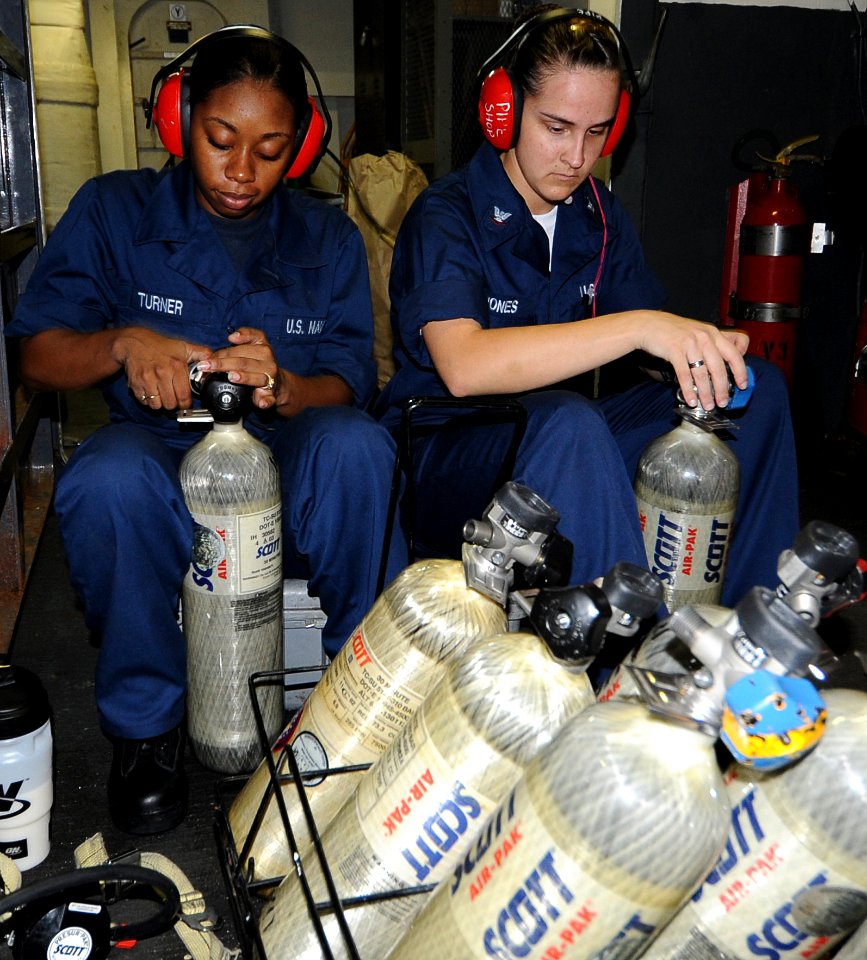 US Navy 100823-N-6427M-004 lectronics Technician Fireman Shanina Turner and Electronics Technician 3rd Class Ashley Jones refill self-contained breathing apparatus tanks aboard the aircraft USS Harry S. Truman (CVN 75)