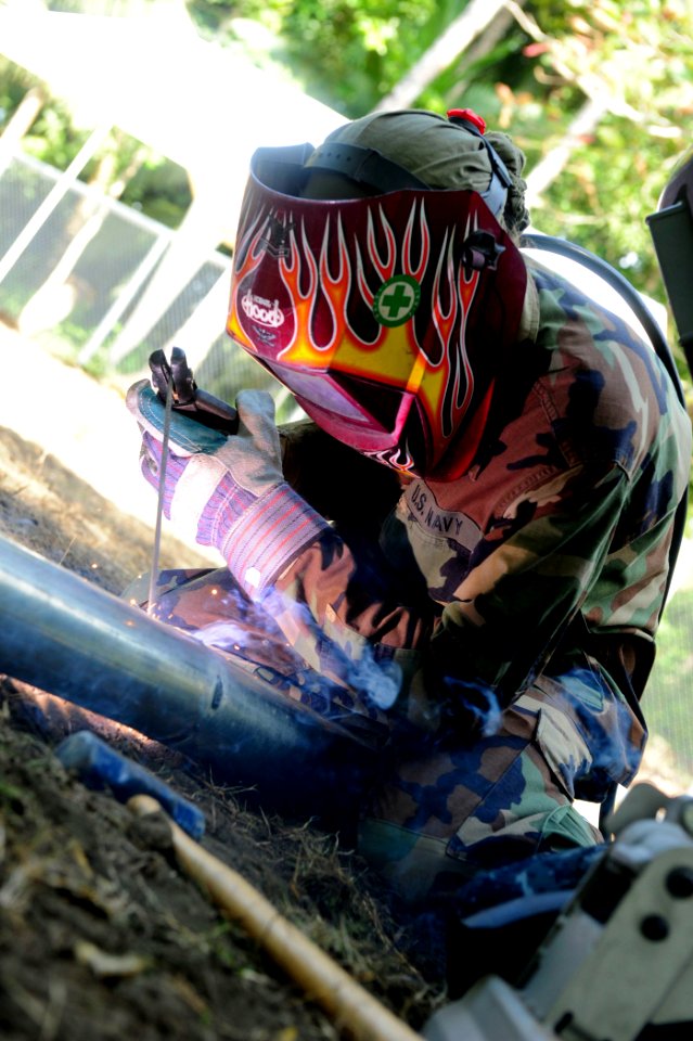 US Navy 100827-N-1531D-130 Steelworker Constructionman Lindzie Bicknell welds two galvanized pipes together to be used on a new fence for a local school during a community relations project in Limon, Costa Rica