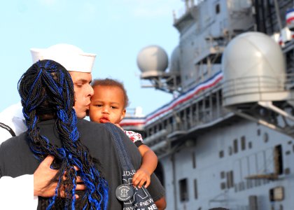 US Navy 100827-N-2855B-069 Operation's Specialist 2nd Class Edward Earskin kisses his wife and 2-month-old daughter before boarding the amphibious assault ship USS Kearsarge (LHD 3)