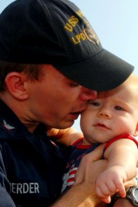 US Navy 100827-N-5292M-031 Machinist Mate 3rd Class John Scherder kisses his eight-month-old daughter goodbye before boarding the amphibious transport dock ship USS Ponce (LPD 15) as the ship prepares to depart Naval Station No
