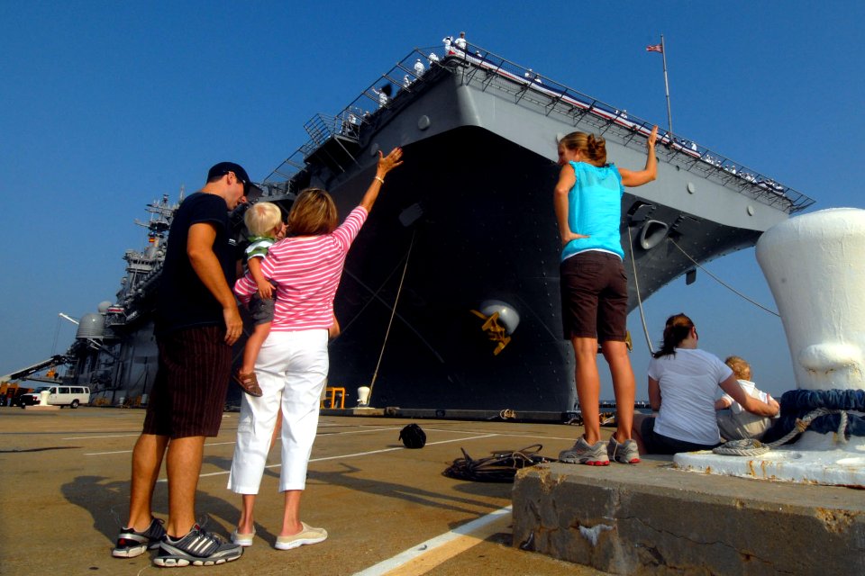 US Navy 100827-N-5292M-011 Family members wave to Lt. Michael St. Jean aboard the amphibious assault ship USS Kearsarge (LHD 3) as the ship prepares to depart Naval Station Norfolk