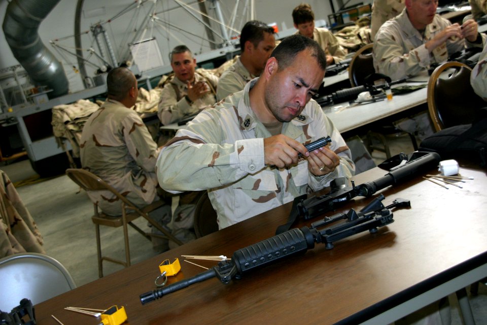 US Navy 100825-N-2888Q-006 Chief Petty Officer Jorge Ornelas cleans his M16 rifle at the end of a combat skills scenario