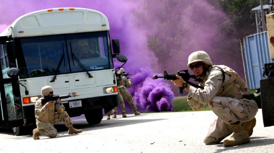 US Navy 100825-N-2888Q-002 Capt. Grafton Chase, right, commander of Navy Expeditionary Logistics Support Group, Lima rotation, takes cover during a combat skills scenario