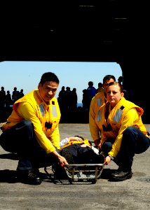 US Navy 100829-N-7908T-257 Sailors assigned to the air department aboard the aircraft carrier USS George H.W. Bush (CVN 77) prepare to lift a Sailor on a stretcher during a mass casualty drill on one of the ship's elevators