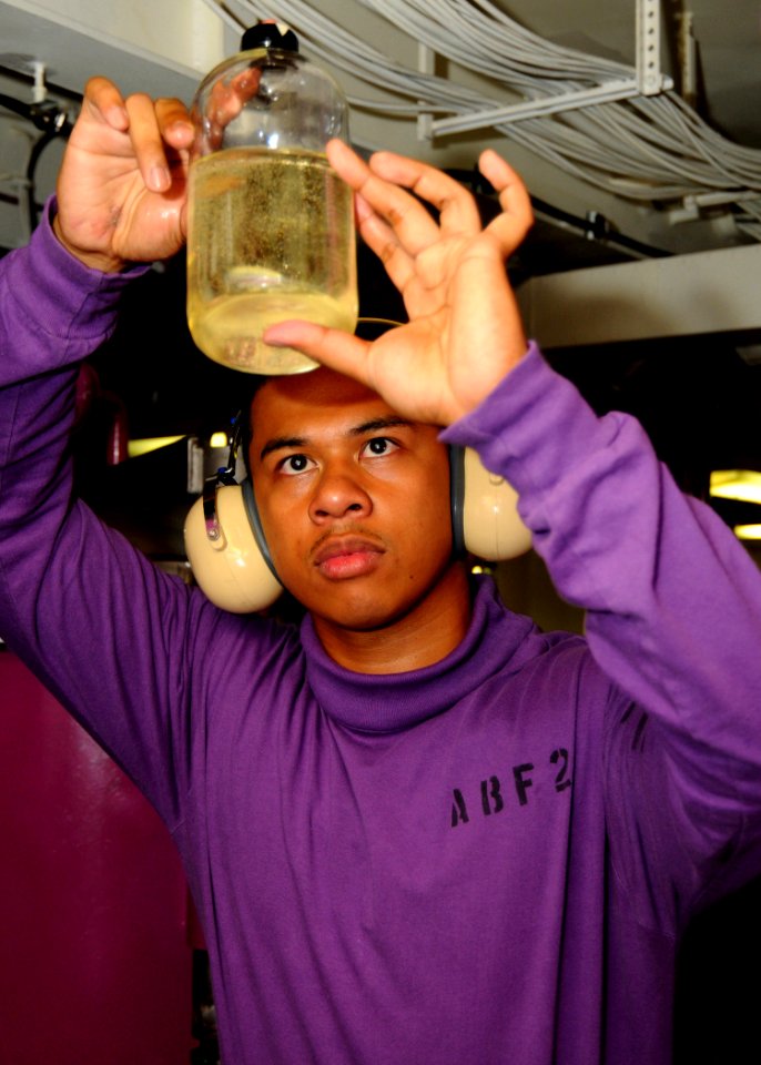 US Navy 100825-N-7908T-004 Aviation Boatswain's Mate (Fuel) 2nd Class Melvin M. Navalta takes a JP-5 fuel sample to ensure it is free from impurities