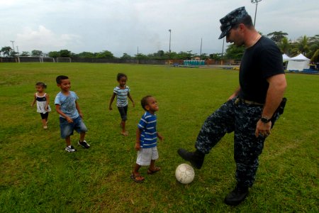 US Navy 100827-N-7680E-243 Ensign Julian Panolli, a nurse from National Naval Medical Center Bethesda embarked aboard the multi-purpose amphibious assault ship USS Iwo Jima (LHD 7), plays soccer with Costa Rican children