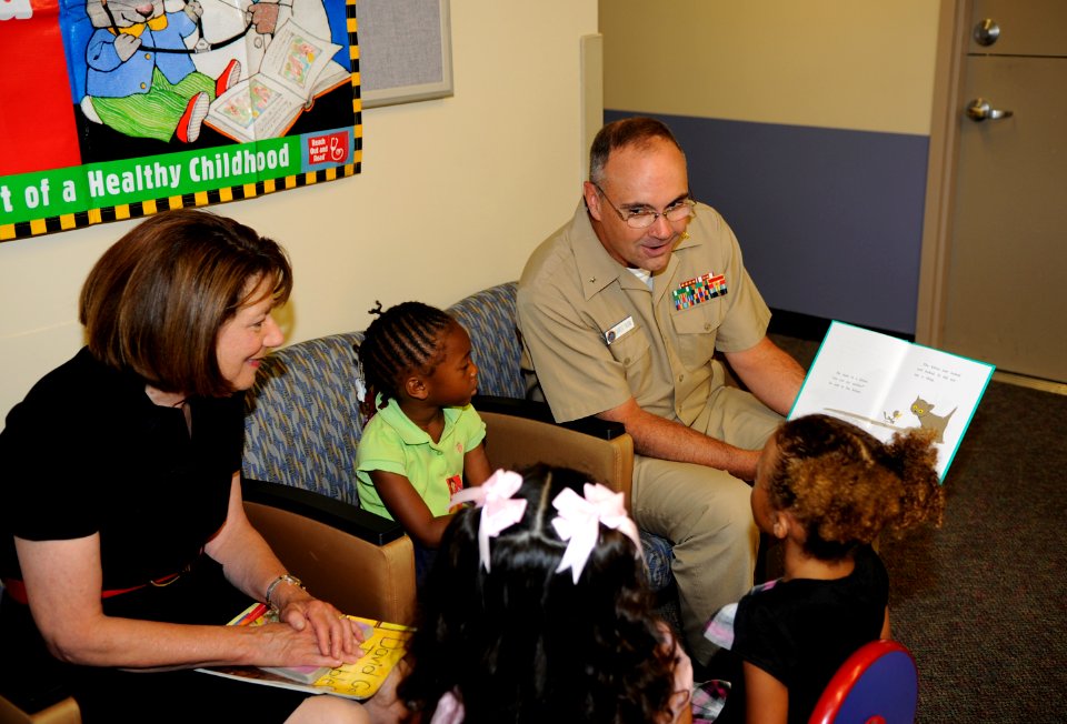 US Navy 100825-N-7032B-273 Rear Adm. C. Forrest Faison III, commander, Naval Medical Center San Diego, reads to children in the pediatrics clinic during a visit by U.S. Rep. Susan Davis to promote children's literacy