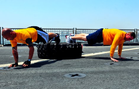 US Navy 100830-N-7948R-454 Operations Specialist 2nd Class Ernest Delacruz, left, and Cryptologic Technician (Technical) 1st Class Jared Pollack perform inverted push ups on the flight deck of the amphibious dock landing ship U