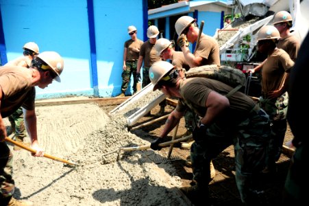 US Navy 100827-N-1531D-290 Seabees embarked aboard USS Iwo Jima (LHD 7) work together to spread cement to make a new floor at a local school during a community relations project in Limon, Costa Rica