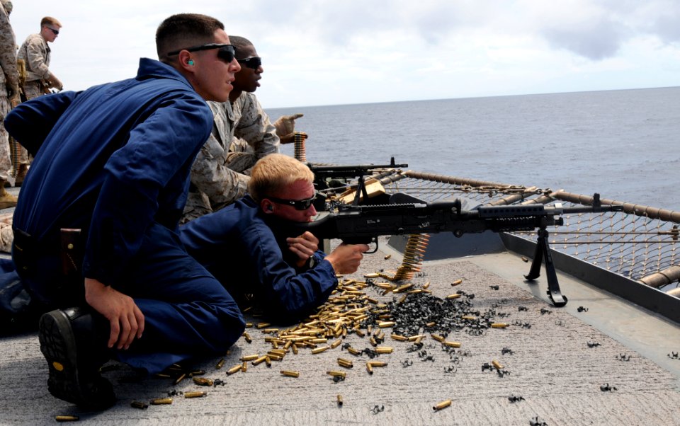 US Navy 100829-N-0864H-901 Gunner's Mate 3rd Class Brandon Field gets target instructions from Gunner's Mate 2nd Class Joshua Pacheco as he fires a .50-caliber machine gun during weapons training