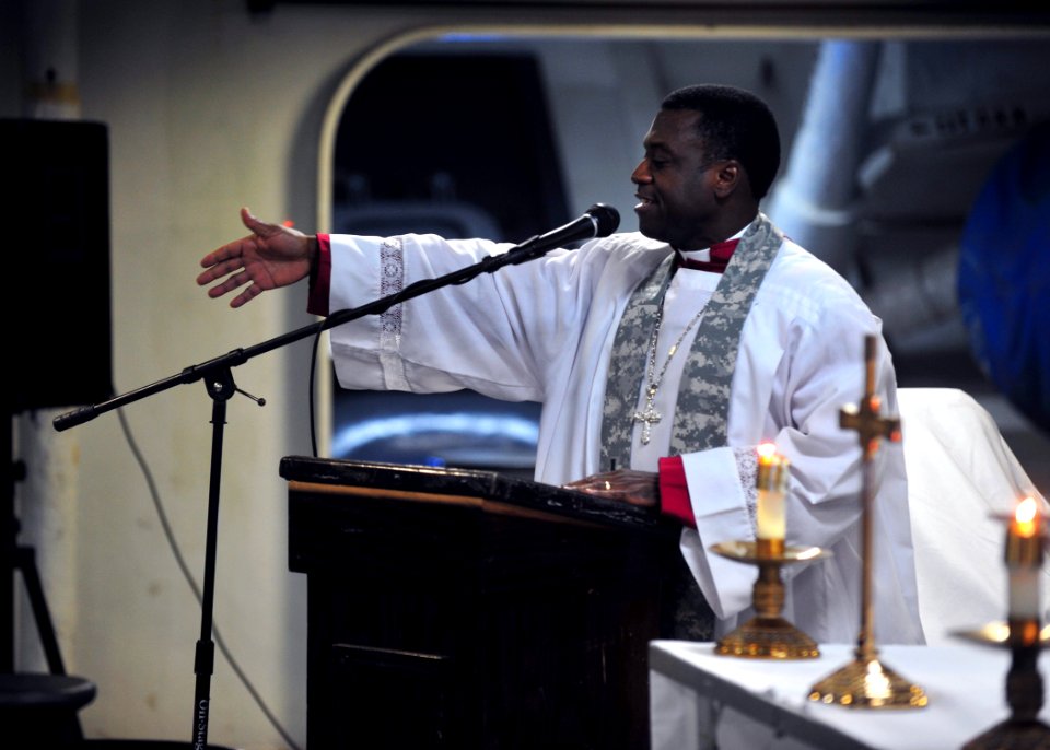 US Navy 100829-N-5838W-021 Senior Chief Aviation Boatswain's Mate (Handling) Earle T. Smith welcomes Sailors to a lay reader-led gospel worship service in the forecastle of the aircraft carrier USS Enterprise (CVN 65)