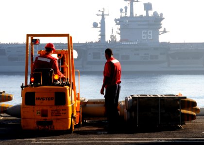 US Navy 100831-N-6632S-069 Sailors assigned to the weapons department aboard the aircraft carrier USS George H.W. Bush (CVN 77) move ordnance in the hangar bay