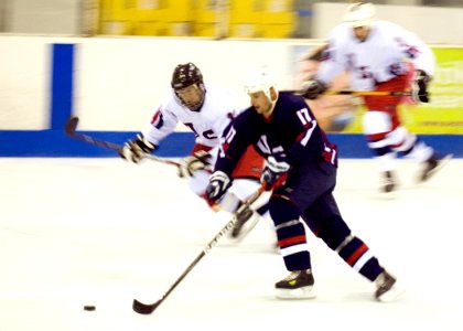 US Navy 100829-N-5476H-108 Information Systems Technician 1st Class Jeremiah Gabbard, assigned to Commander, U.S. Pacific Fleet, moves the puck down the ice in the second period of the inaugural Wounded Warriors Charity Hockey