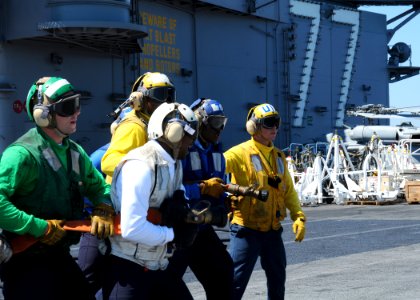 US Navy 100829-N-7908T-060 Sailors assigned to the air department aboard the aircraft carrier USS George H.W. Bush (CVN 77) perform hose sweeping movements during a flight deck drill