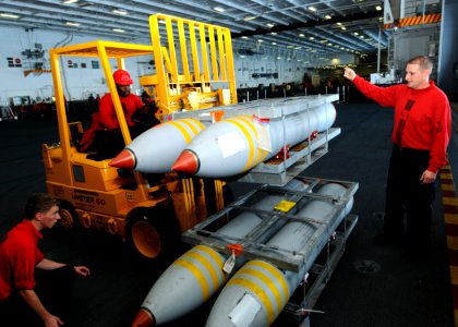 US Navy 100831-N-6632S-038 Sailors assigned to the weapons department aboard the aircraft carrier USS George H.W. Bush (CVN 77) move ordnance in the hangar bay