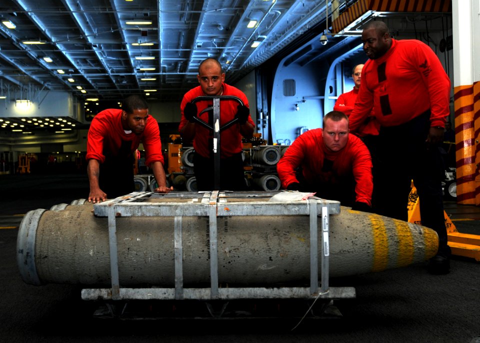 US Navy 100831-N-6632S-139 Sailors assigned to the weapons department aboard the aircraft carrier USS George H.W. Bush (CVN 77) move ordnance in the hangar bay