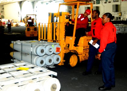 US Navy 100830-N-7908T-127 Sailors assigned to G-5 Division of the weapons department of the aircraft carrier USS George H.W. Bush (CVN 77), move ammunition in the ship's hangar bay