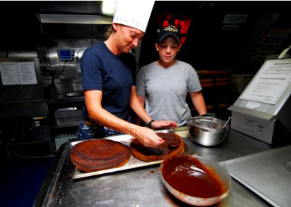 US Navy 100830-N-4044H-073 Chief Information Systems Technician Liauanna Conner, left, and Royal Australian Navy Boatswain's Mate Able Seaman Jo Russell prepare a cake for a sailor's birthday celebration