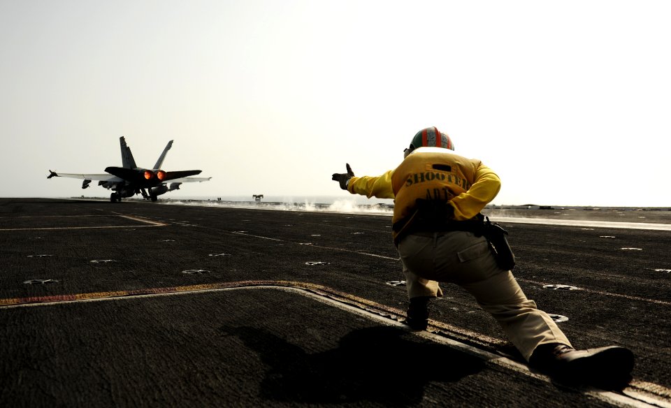 US Navy 100830-N-6362C-109 A flight deck shooter aboard USS Harry S. Truman (CVN 75) signals for the launching of an F-A-18C Hornet
