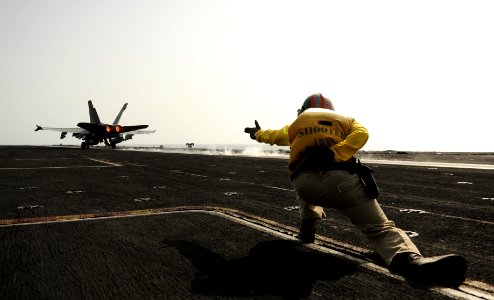 US Navy 100830-N-6362C-109 A flight deck shooter aboard USS Harry S. Truman (CVN 75) signals for the launching of an F-A-18C Hornet
